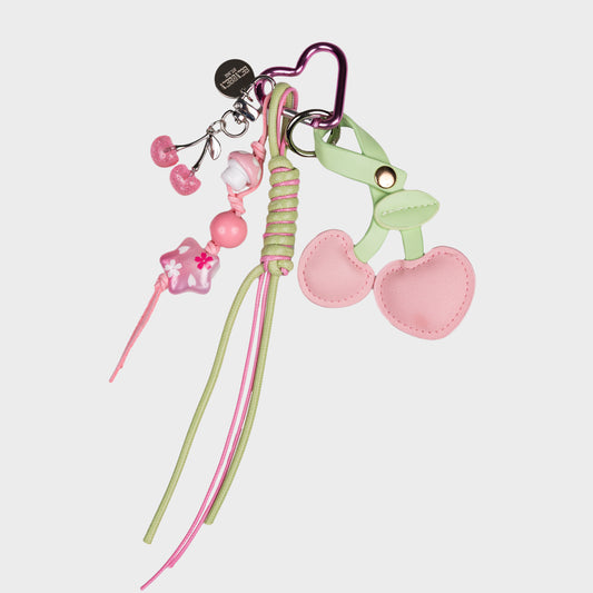 Vaaleanpunainen kirsikka laukkukoru, missä on lisänä roikkuva tähtikoriste ja pienempi kirsikka.