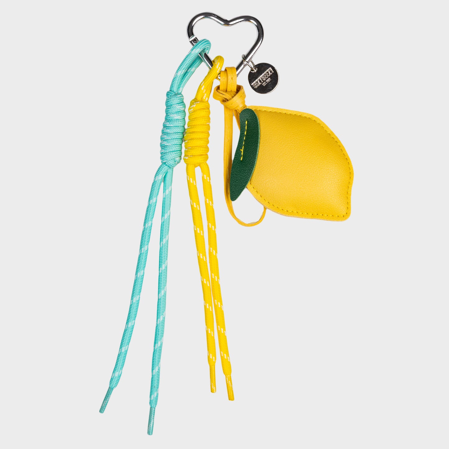 Keltainen sitruunalaukkukoru, missÀ sitruuna ja kaksi roikkuvaa nauhaa