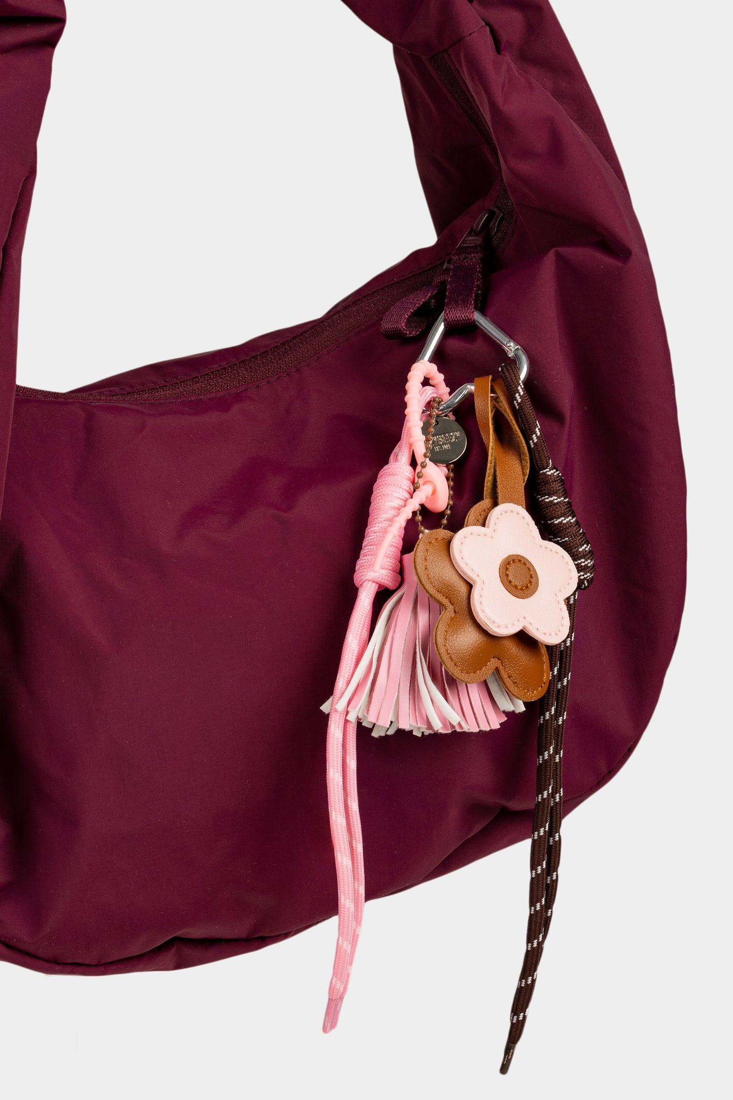Vaaleanpunainen kukkalaukkukoru kuvattuna viininpunaisessa laukussa.