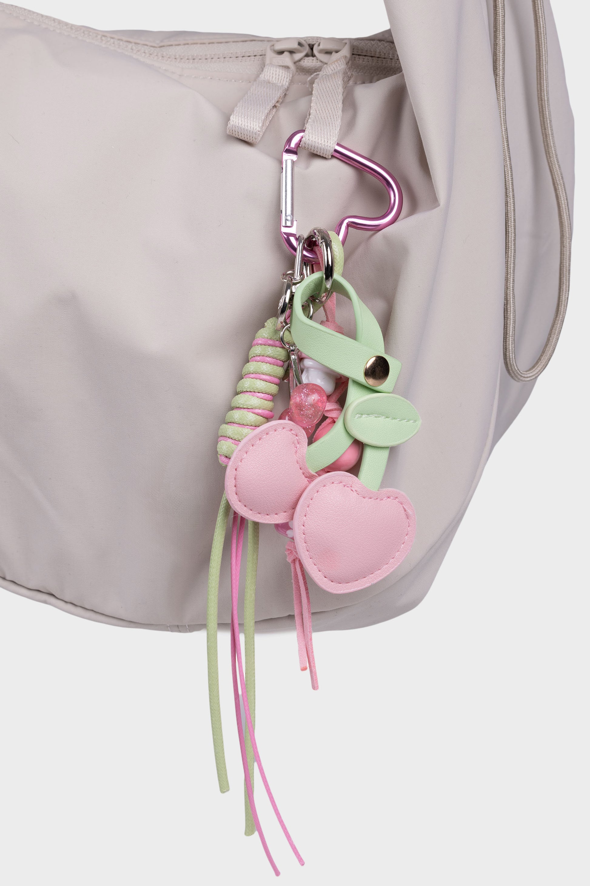 Vaaleanpunainen kirsikkalaukkukoru kuvattuna beigessä laukussa.